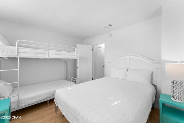 bedroom featuring visible vents and wood finished floors
