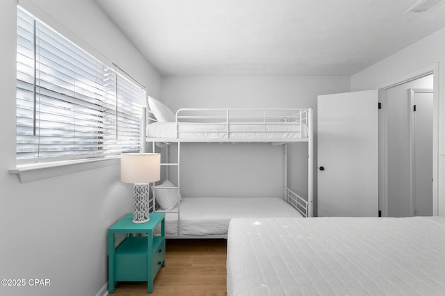 unfurnished bedroom featuring visible vents and wood finished floors