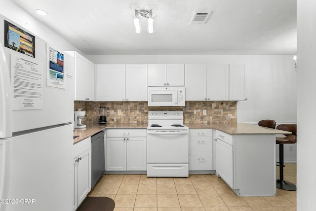 kitchen featuring white cabinets, tasteful backsplash, white appliances, and a peninsula