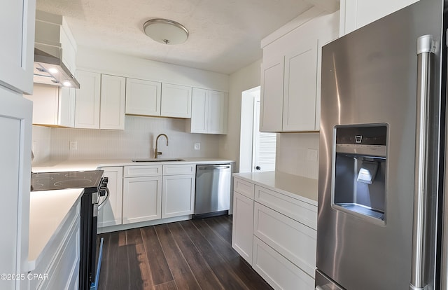kitchen with a sink, stainless steel appliances, light countertops, white cabinets, and dark wood-type flooring
