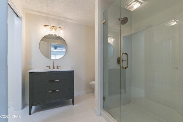 bathroom featuring a shower stall, tile patterned floors, toilet, vanity, and a textured ceiling
