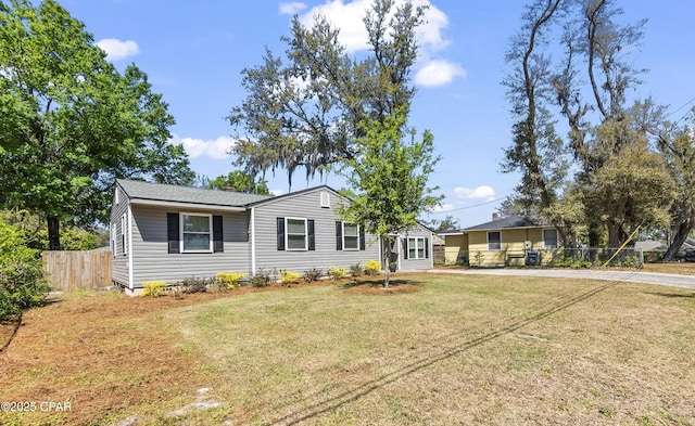 view of front of house with a front lawn and fence