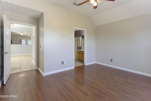 spare room with vaulted ceiling, baseboards, a ceiling fan, and dark wood-style floors