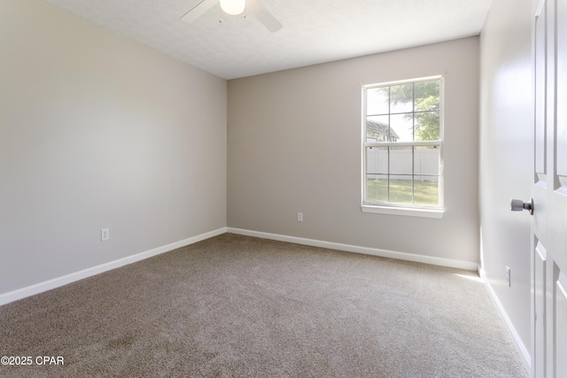 carpeted empty room with baseboards and a ceiling fan