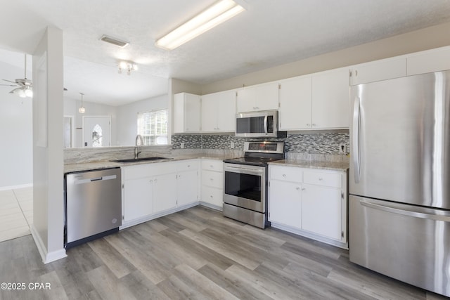 kitchen featuring ceiling fan, visible vents, appliances with stainless steel finishes, a sink, and white cabinets