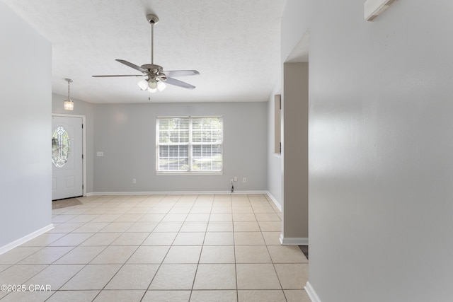 interior space featuring a healthy amount of sunlight, light tile patterned floors, ceiling fan, and baseboards