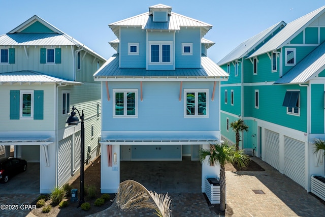 13643 Front Beach Rd, Panama City Beach, FL 32413 - coastal inspired home featuring a standing seam roof, decorative driveway, a metal roof, and a carport