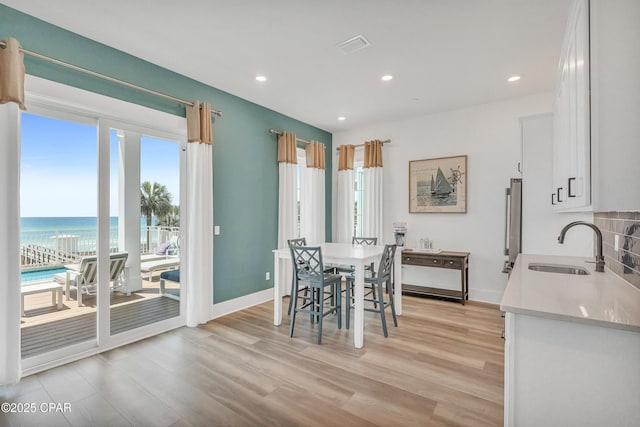 13643 Front Beach Rd, Panama City Beach, FL 32413 - dining area with light wood finished floors, recessed lighting, and a water view