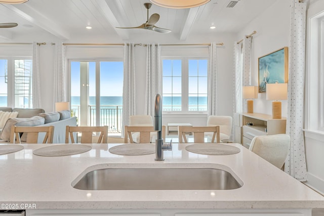 13643 Front Beach Rd, Panama City Beach, FL 32413 - kitchen with beam ceiling, plenty of natural light, a water view, open floor plan, and light stone countertops
