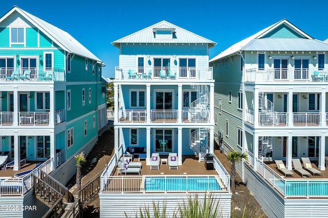 13643 Front Beach Rd, Panama City Beach, FL 32413 - back of property with an outdoor hangout area, a balcony, a community pool, a standing seam roof, and a metal roof