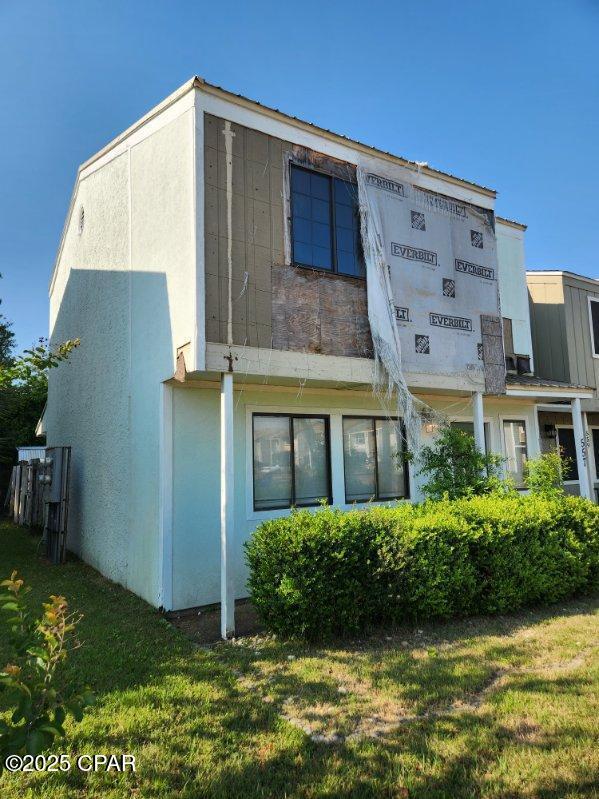 557 Palermo Rd, Panama City, FL 32405 - rear view of house with a yard and stucco siding