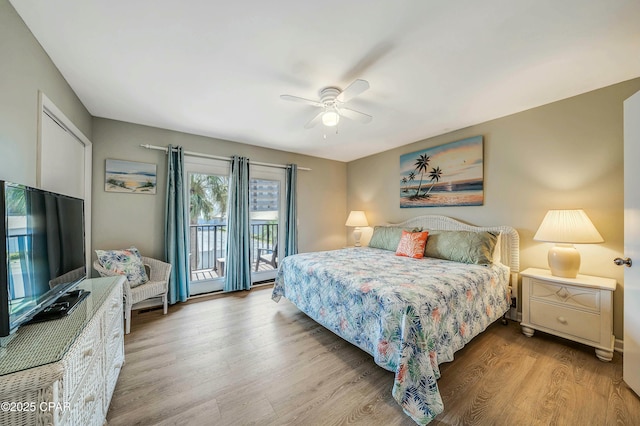 bedroom with ceiling fan, access to outside, and wood finished floors