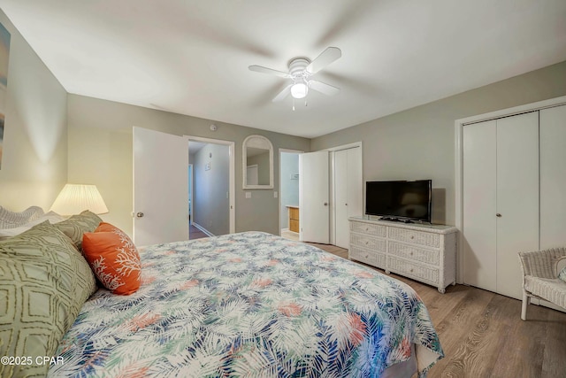 bedroom with multiple closets, ceiling fan, and wood finished floors