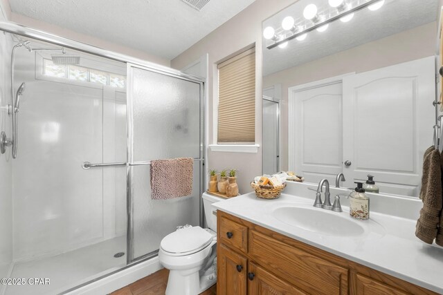 full bathroom with a shower stall, vanity, and toilet