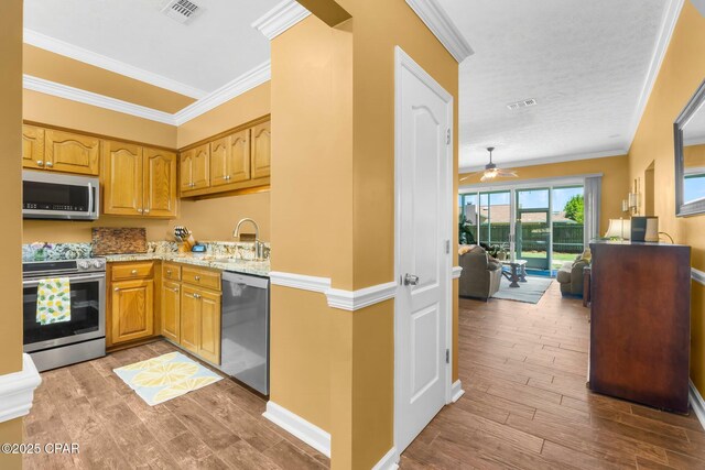kitchen featuring a sink, visible vents, appliances with stainless steel finishes, and wood finished floors