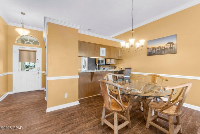 dining room with ornamental molding, baseboards, an inviting chandelier, and dark wood-style floors