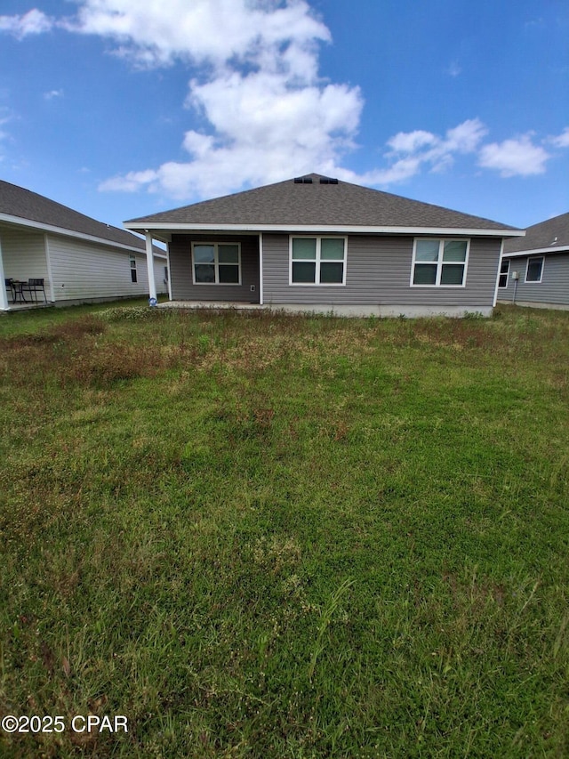 rear view of house with a yard