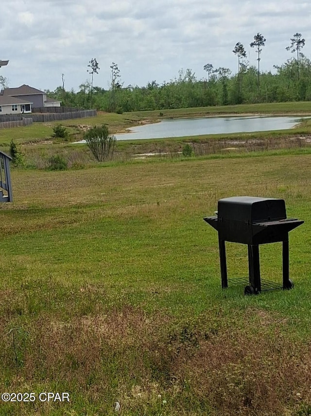view of property's community with a yard and a water view
