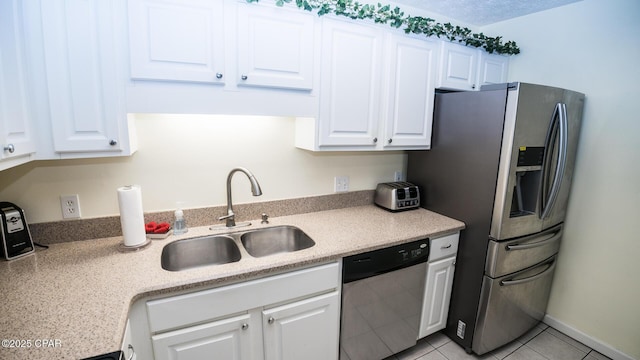 kitchen with white cabinets, stainless steel appliances, light countertops, a sink, and light tile patterned flooring