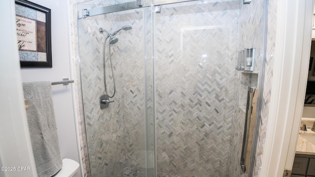 bathroom featuring vanity, toilet, and a stall shower