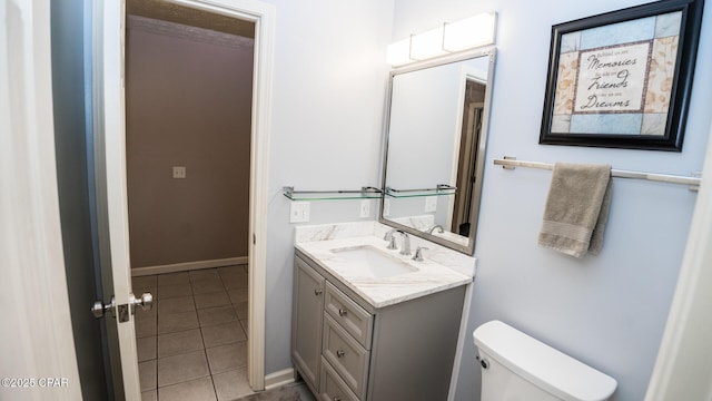 bathroom with tile patterned floors, baseboards, vanity, and toilet