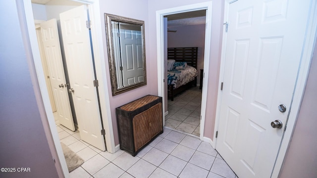 hallway with baseboards and light tile patterned floors