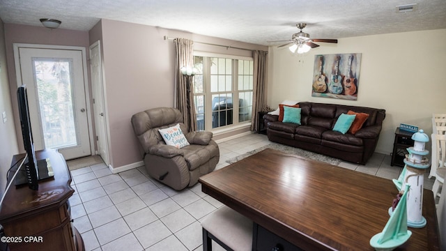 living room with a wealth of natural light, visible vents, and light tile patterned floors