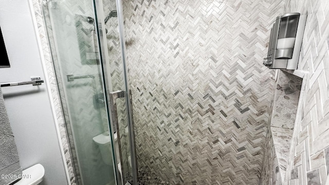bathroom featuring toilet and a stall shower