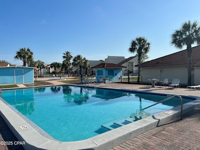 pool with an outdoor structure, a residential view, and a shed