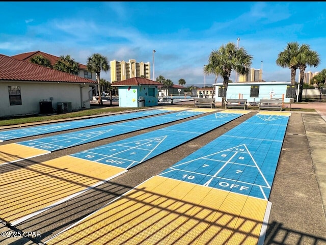 view of community featuring fence and shuffleboard