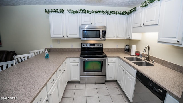 kitchen featuring white cabinets, stainless steel appliances, and a sink