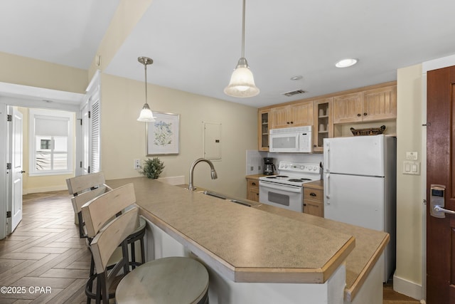 9300 Baytowne Wharf Blvd Unit 528/530, Miramar Beach, FL 32550 - kitchen with white appliances, a sink, a peninsula, a kitchen bar, and glass insert cabinets