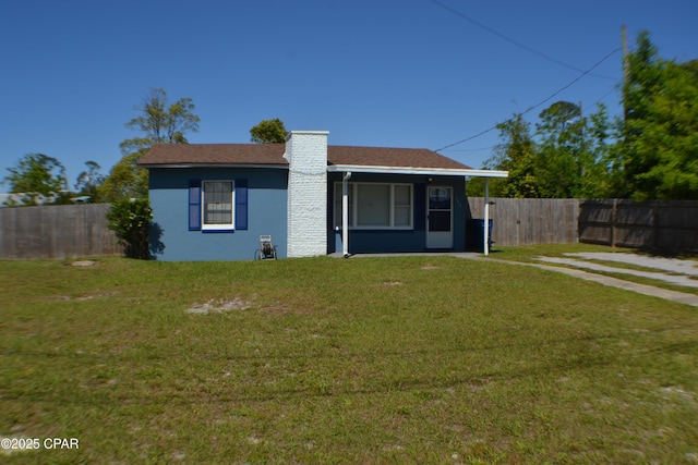 view of front of property featuring fence, a front yard, and stucco siding