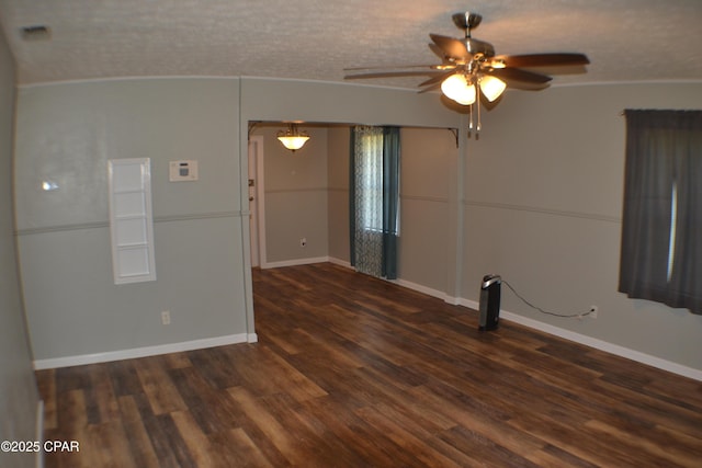 spare room with baseboards, a ceiling fan, and dark wood-style floors
