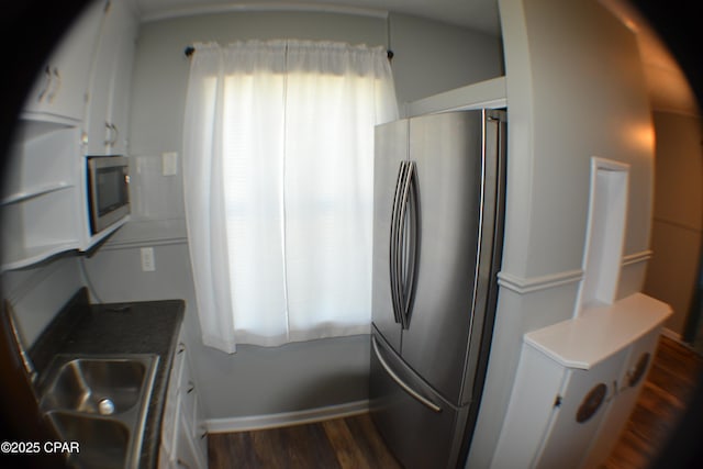 kitchen with dark wood-type flooring, stainless steel appliances, and a sink