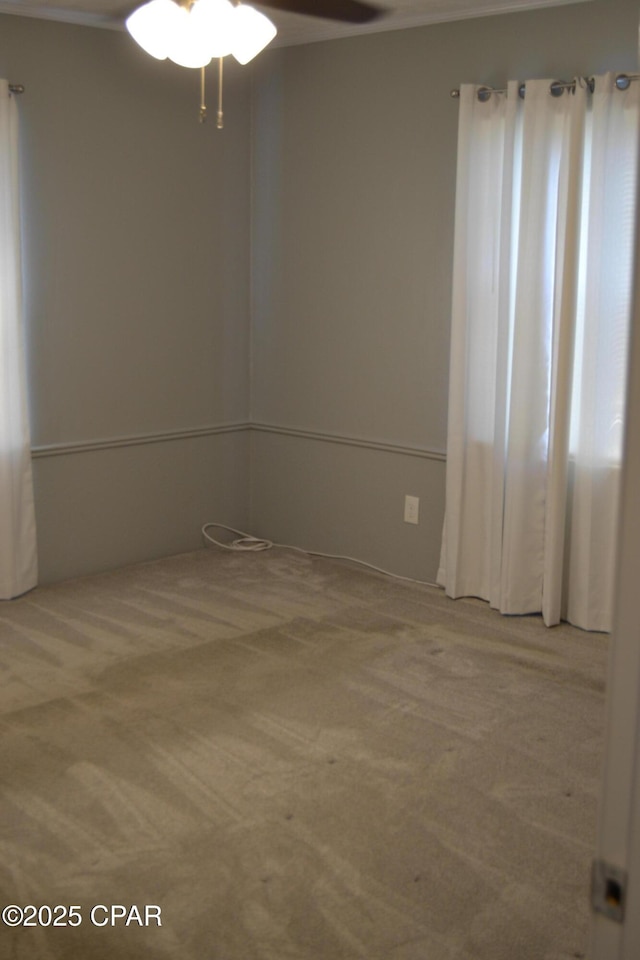 carpeted spare room with a ceiling fan
