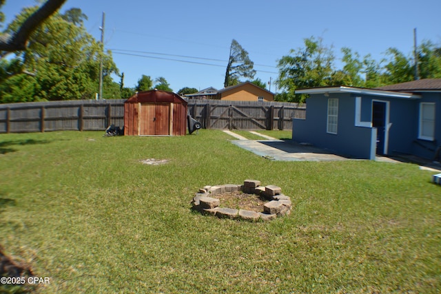 view of yard with a fenced backyard, an outdoor structure, a patio, and a shed