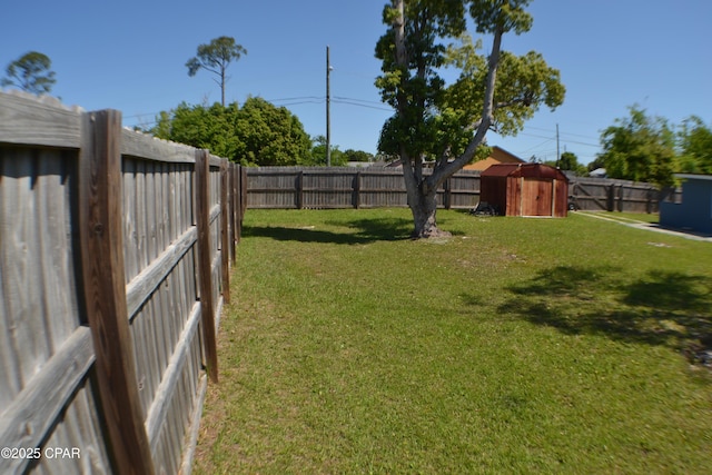view of yard featuring a fenced backyard, an outbuilding, and a storage shed