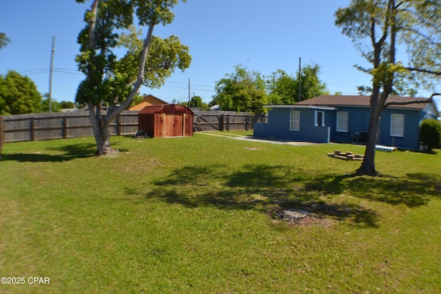 view of yard with an outdoor structure, a patio, a shed, and a fenced backyard