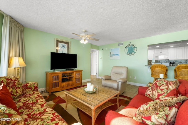 10509 Front Beach Rd Unit 300, Panama City Beach, FL 32407 - living area with light tile patterned floors, ceiling fan, baseboards, visible vents, and a textured ceiling
