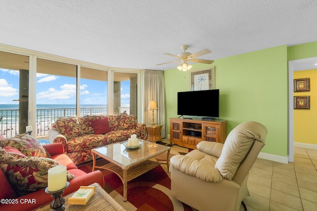 10509 Front Beach Rd Unit 300, Panama City Beach, FL 32407 - living area featuring light tile patterned floors, a textured ceiling, a water view, baseboards, and a ceiling fan
