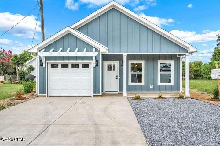 1549 Chandlee Ave Unit A, Panama City, FL 32405 - view of front of home featuring an attached garage, board and batten siding, driveway, and a porch