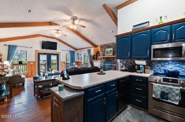 kitchen with a ceiling fan, a peninsula, open floor plan, and stainless steel appliances