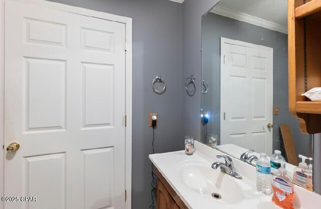 bathroom with ornamental molding and vanity