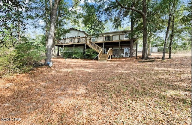 back of property with a wooden deck and stairs