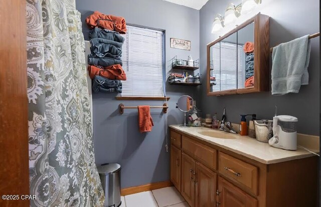 bathroom featuring tile patterned floors, baseboards, vanity, and curtained shower