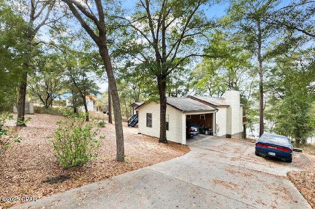 view of side of property with a chimney and a garage