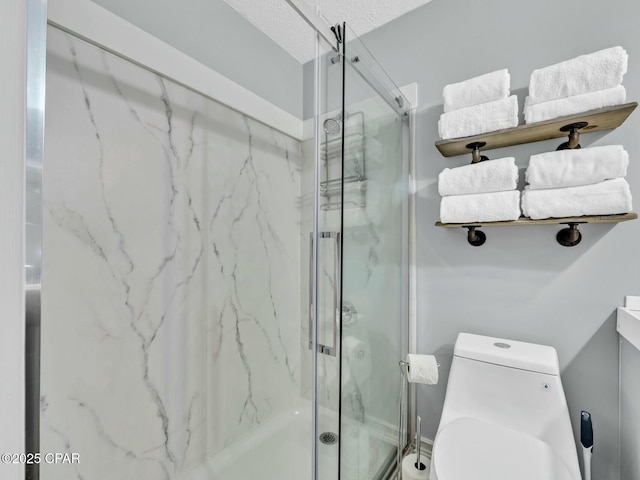 bathroom featuring toilet, a textured ceiling, and a marble finish shower