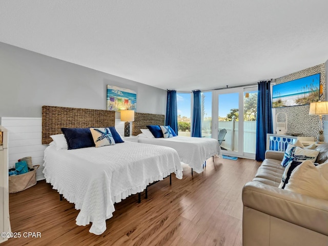 bedroom with wood finished floors and access to outside