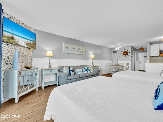 bedroom featuring wainscoting and light wood-style floors